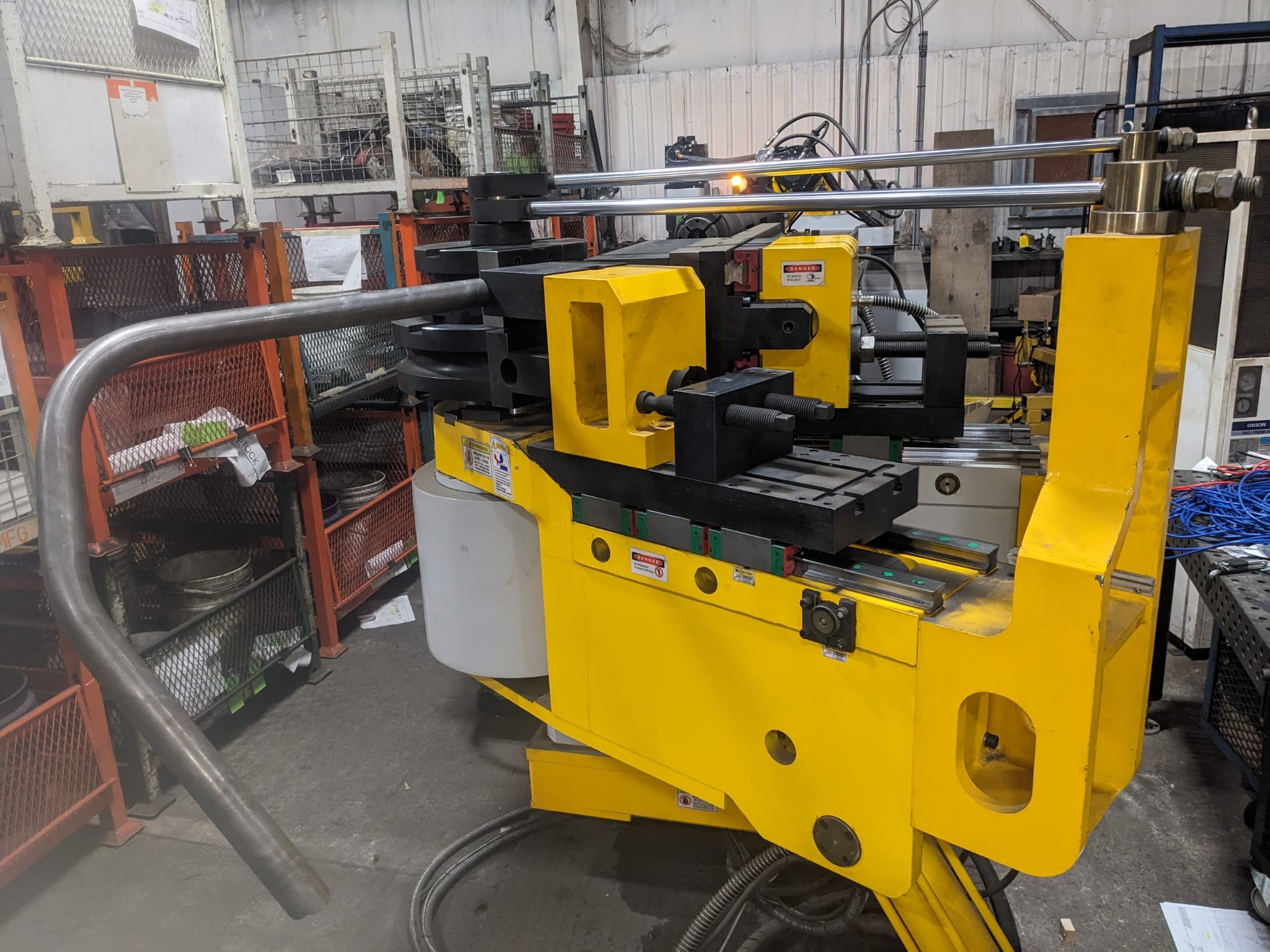 Steel tube component midway through forming in a CNC tube bender at Seaborn Manufacturing