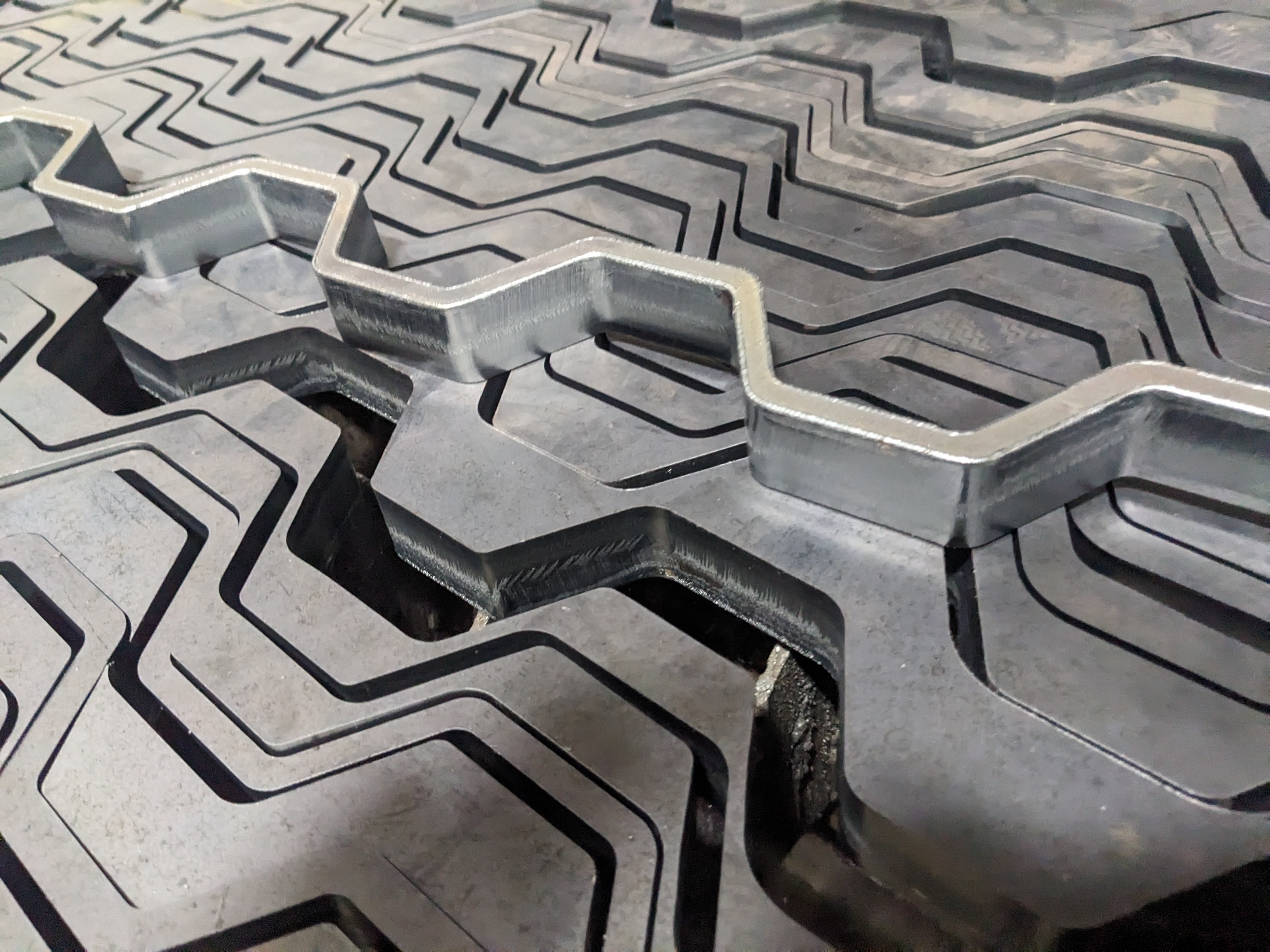 Finished 0.315-inch-wide grate strips laser cut from 1-inch carbon steel plate